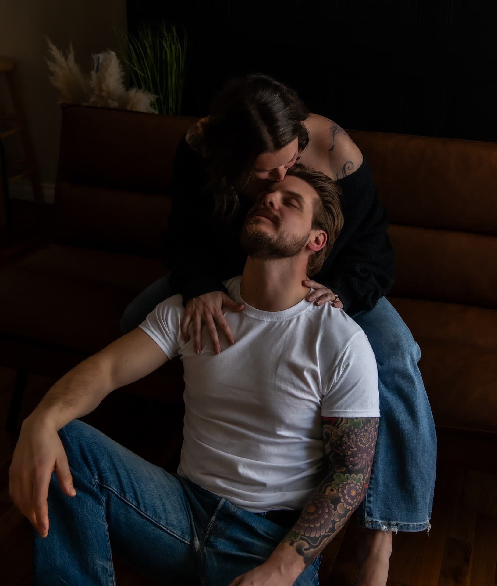 Couple in jeans and a white tee holding each other close, couples boudoir in St. Albert